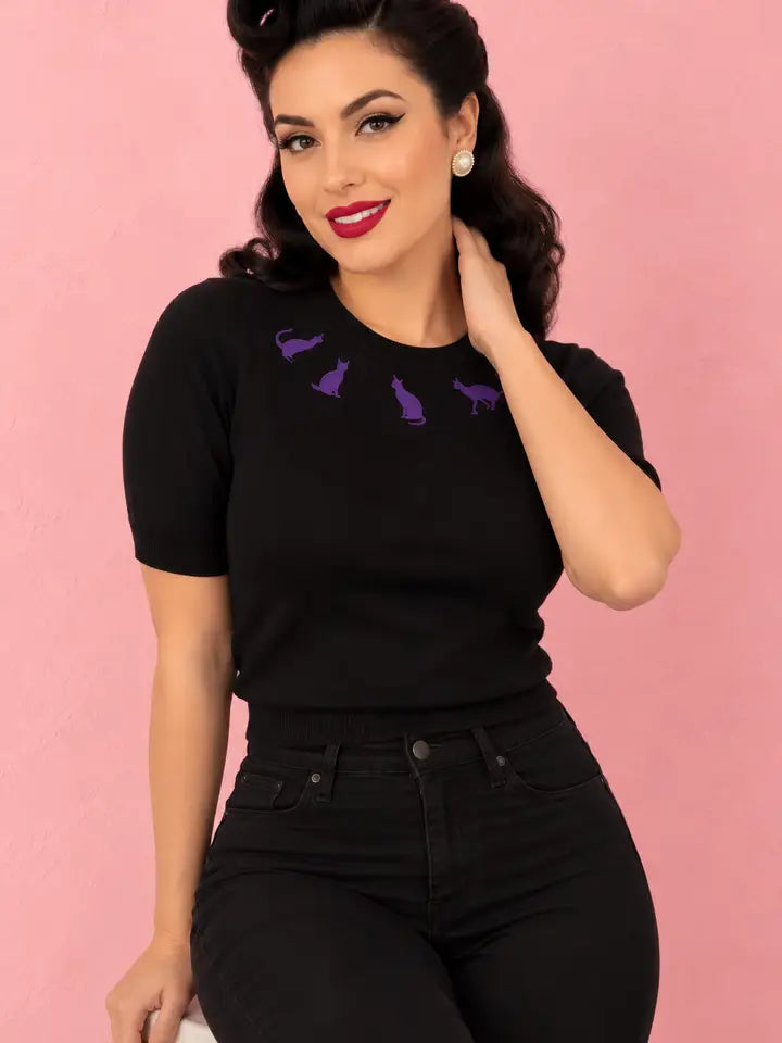 Hemet black short-sleeve knit top with four purple embroidered cats, model view