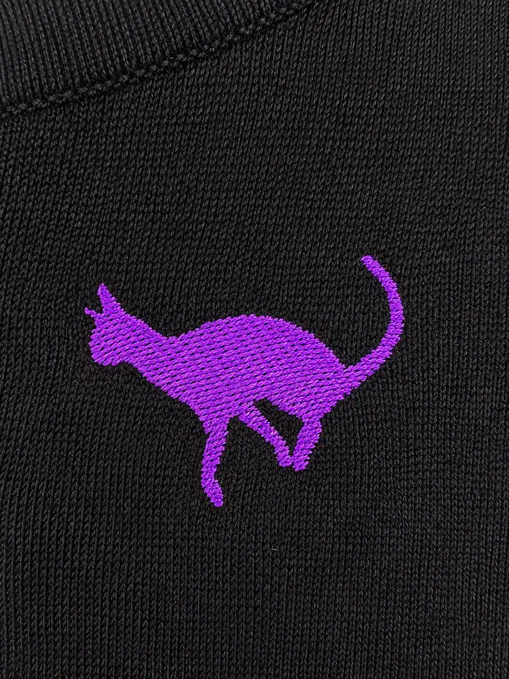 Close-up of purple cat embroidery on the black Hemet knit top
