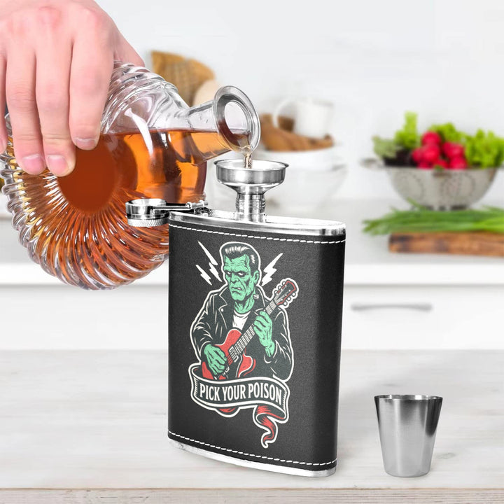 Person pouring liquor from a decanter into a retro black hip flask featuring Pick Your Poison design, in a kitchen setting.