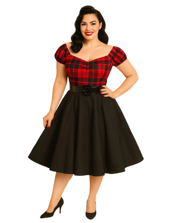Woman wearing a red plaid top and black skirt with a belt against a beige background