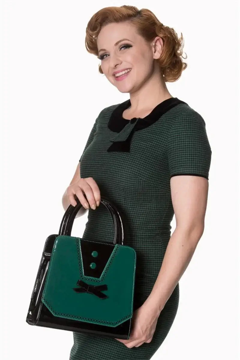 Model showcasing Rosemary's Bag teal handbag with bow detail, wearing a retro-chic outfit.