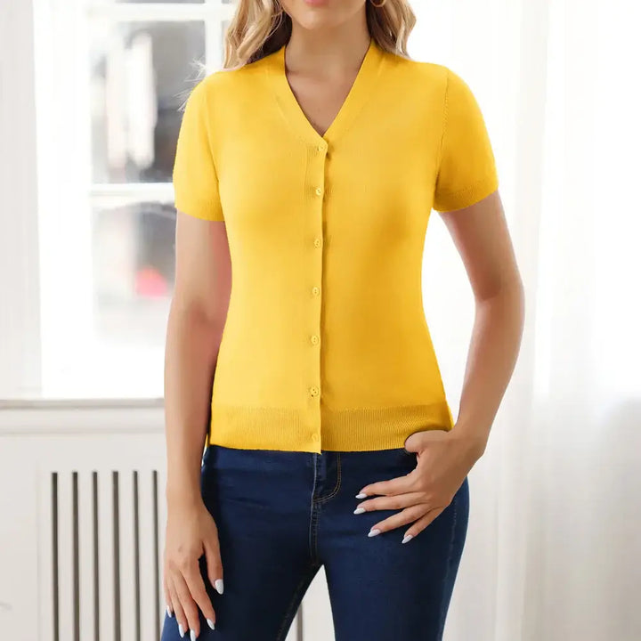 Short sleeve yellow V-neck button-up cardigan paired with jeans, perfect for stylish layering.