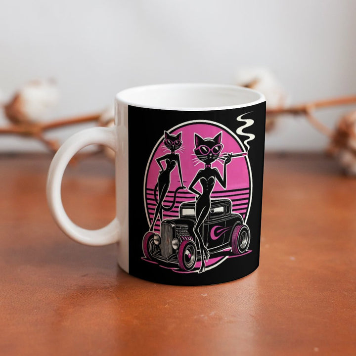 Retro coffee mug featuring stylish pin-up cats and classic car design, perfect for coffee or tea lovers.