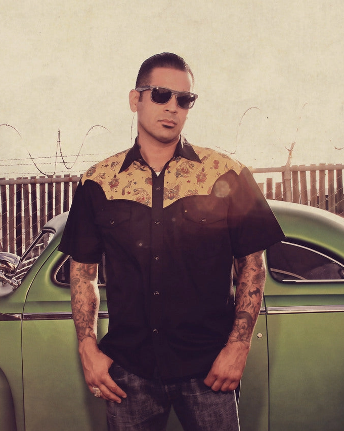 Model wearing Steady Clothing Tattoo Flash western shirt beside a green custom car
