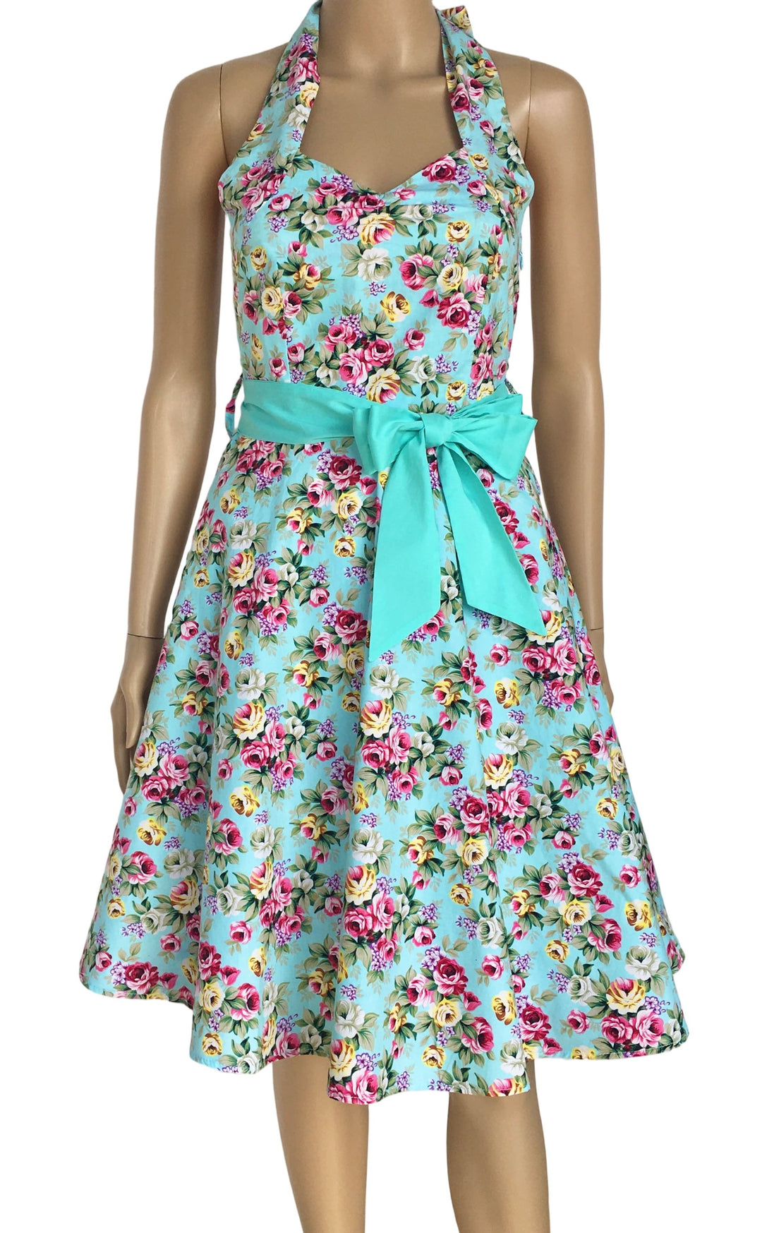 Floral dress with a turquoise belt on a mannequin against a white background