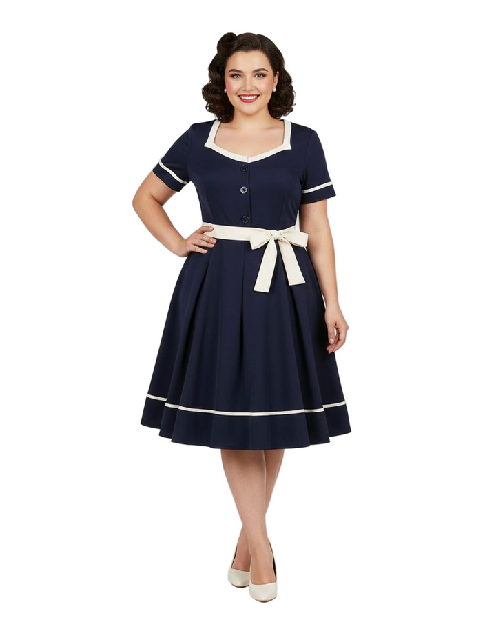 Woman wearing a navy dress with white accents on a white background