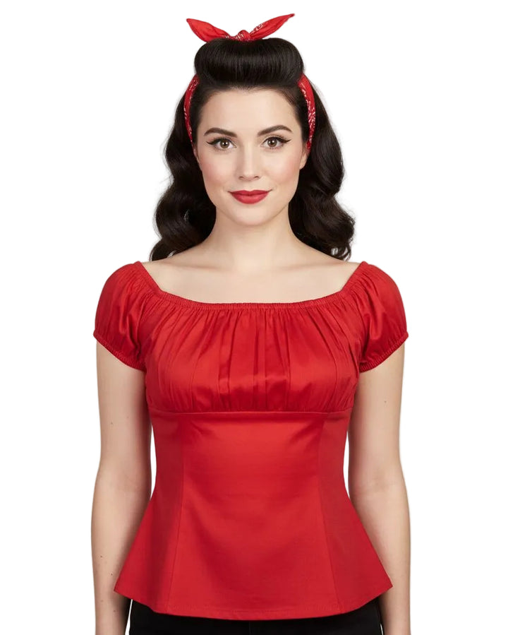 Woman wearing a red top with a plain background