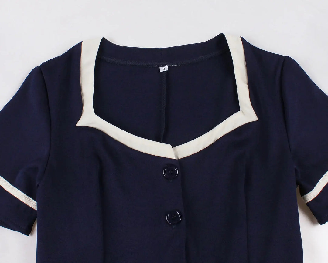 Vintage 1950s Navy Swing Dress featuring a navy fabric and elegant contrast white trim.