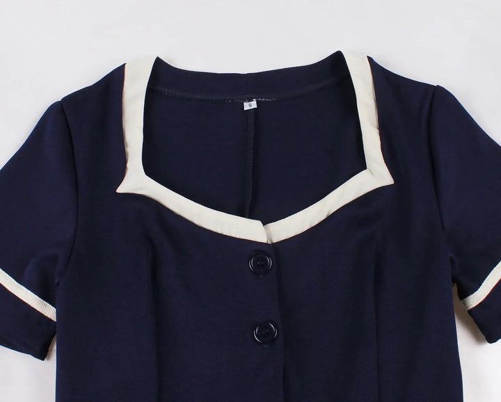 Vintage 1950s Navy Swing Dress featuring a navy fabric and elegant contrast white trim.